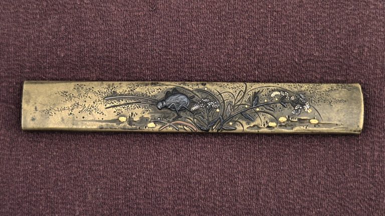 The Hamano Noriyuki kozuka: a dark cricket among grasses, silver blossom clusters and gold pebbles on a pitted sentoku ground.