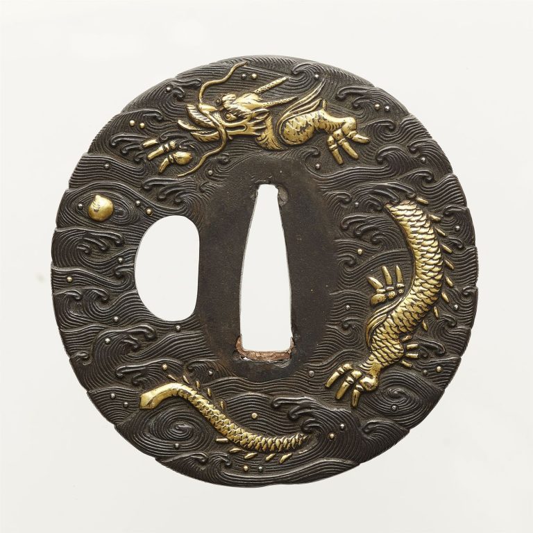 Round shibuichi tsuba covered in finely cut waves: a coiled gold dragon at the top, a small gold jewel floating in the waves beside it.