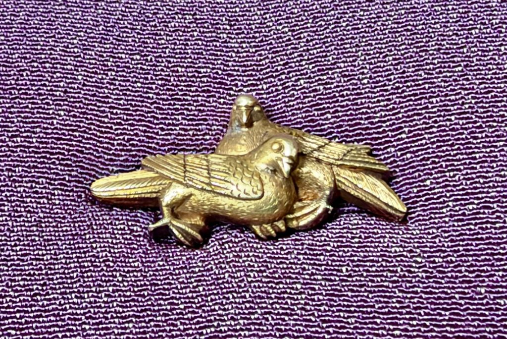 One menuki: a dove with folded wings in front, and a second dove behind it with its wings spread.