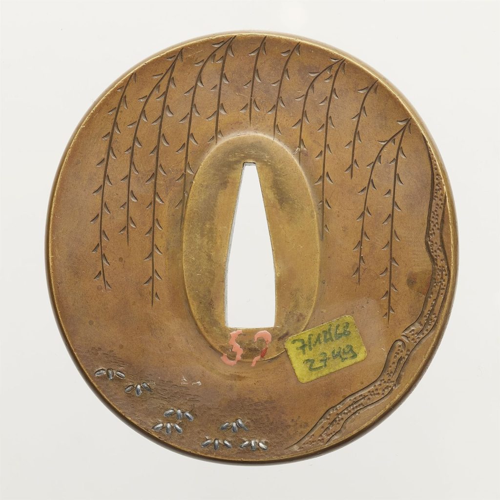 The back of the Okamoto Sadamasa tsuba: a weeping willow with small three-leaved plants beneath it, the Lempertz auction label from 1968 still on the plate.