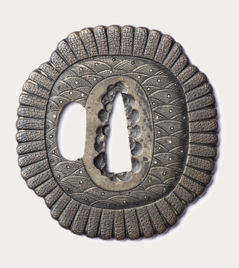 The other face, also covered with seigaiha, the tang opening lined with small plugs.