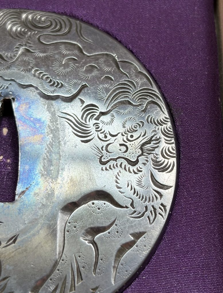 Detail of the shishi, its face turned toward the center, its mane cut in tight curls.