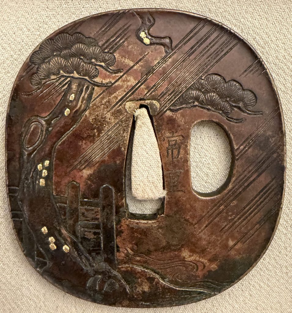 The signed back: an old pine with a knot hole rises along the left edge, a wooden fence stands in the rain, and the signature Tsuneshige is cut beside the central opening.