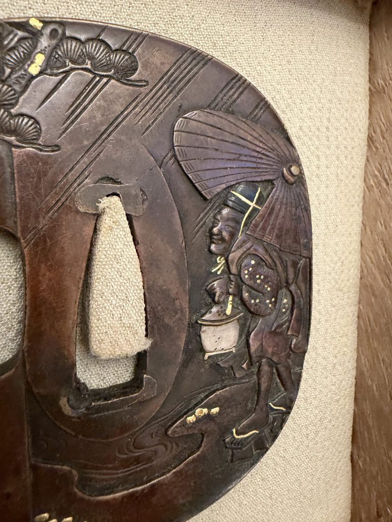Detail: the old man under the umbrella, his robe dotted with gold, the lantern held low in his hand.